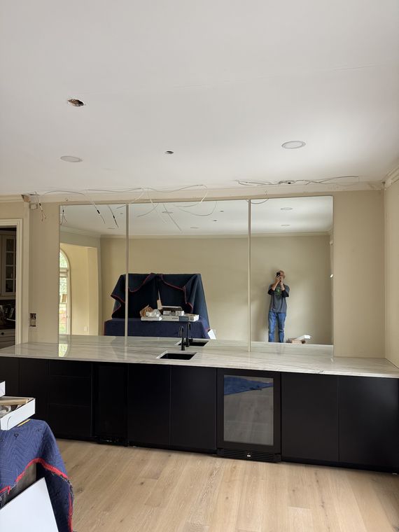 Large custom wall mirror installed above a bar